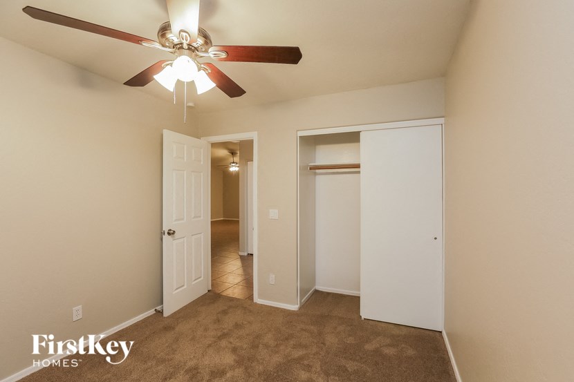 a bedroom with a ceiling fan and a closet