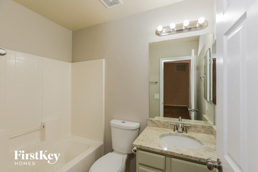 a bathroom with a sink toilet and a mirror