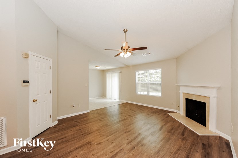 a living room with a fireplace and a ceiling fan