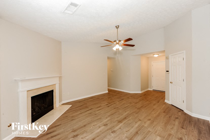 a living room with a fireplace and a ceiling fan