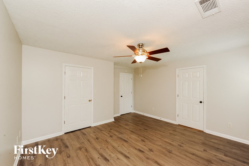 the living room of an empty house with a ceiling fan