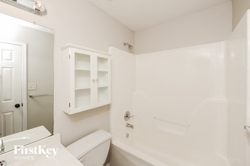 a white bathroom with a tub and a toilet and a sink