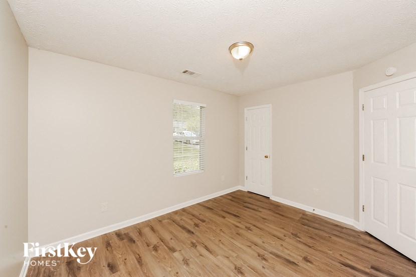 an empty living room with white walls and wood floors