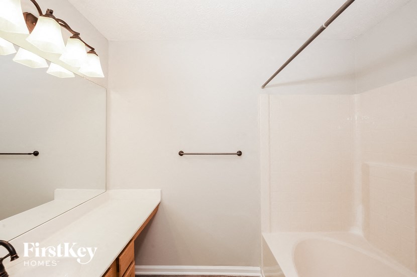 a bathroom with a tub and a sink and a mirror