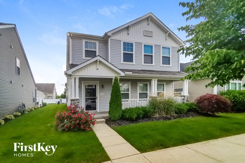 a house with a lawn and a sidewalk in front of it