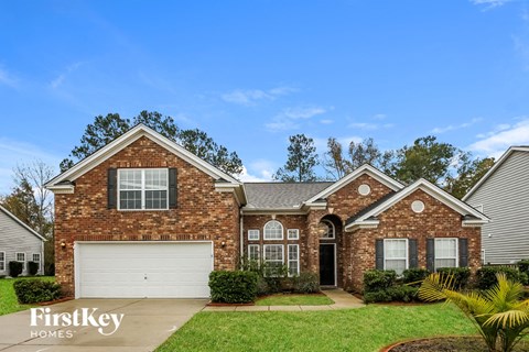 A brick house with a garage door and a sign that says FirstKey Homes.