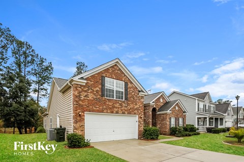 A house with a garage and a brick chimney is for sale.
