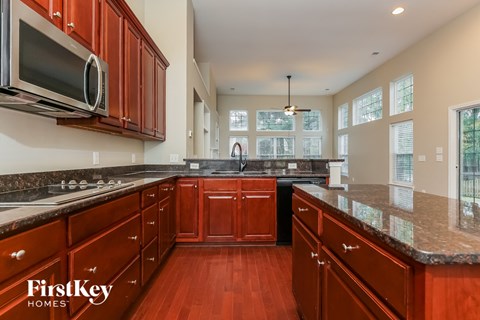 A kitchen with wooden cabinets and a FirstKey Homes logo.