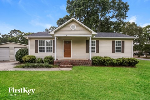 A house with a brown door and a brick step in front.