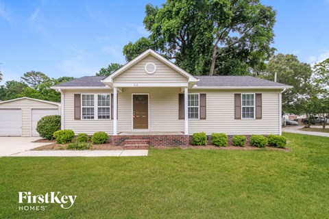 A house with a brown door and a brick border in front.