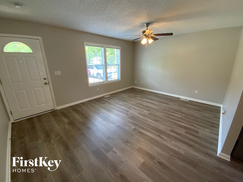 A room with wooden flooring and a ceiling fan.