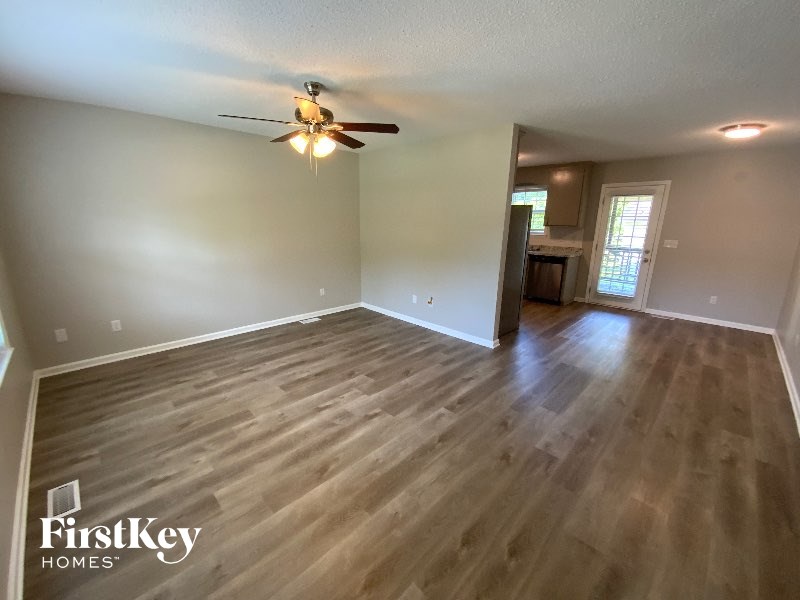 A room with wooden flooring and a ceiling fan.