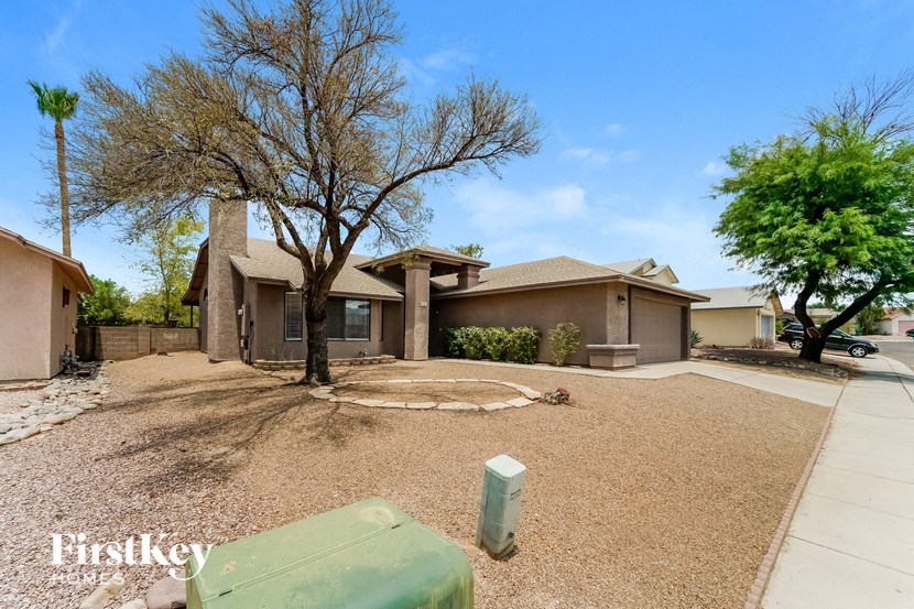a house with a driveway and a tree in front of it