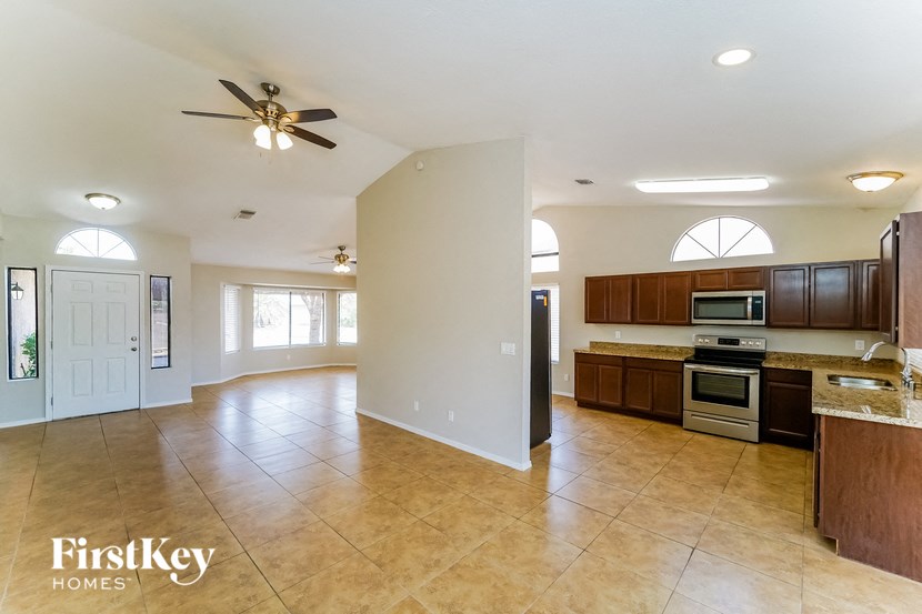 an empty kitchen and living room with a ceiling fan