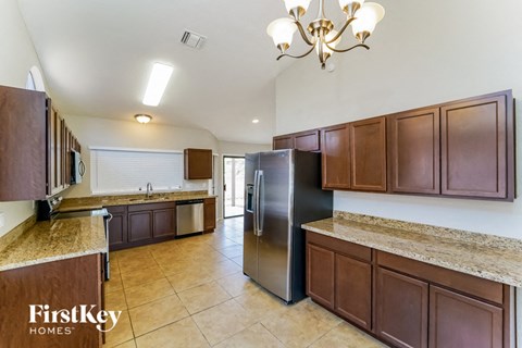 a large kitchen with stainless steel appliances and wooden cabinets