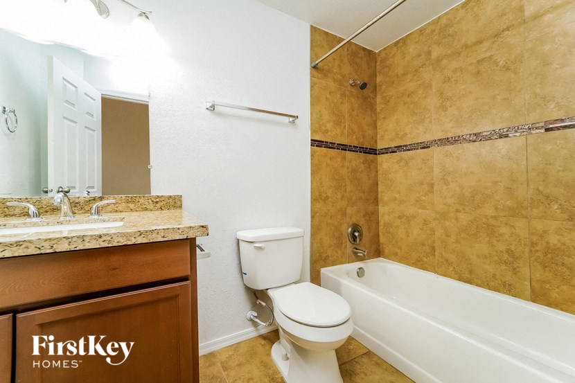 a bathroom with a toilet and a tub and a sink