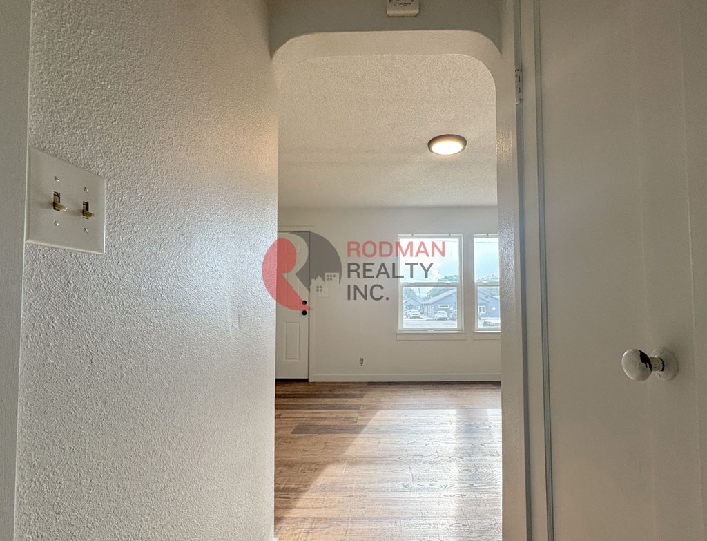 A hallway with a Rodman Realty Inc. sign on the wall.