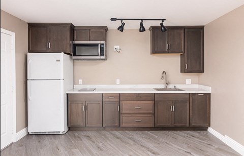 a kitchen with wooden cabinets and a white refrigerator