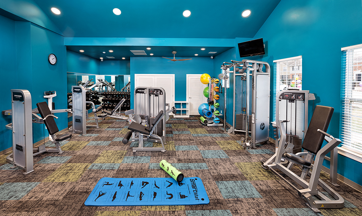 a gym with cardio machines and weights on the floor