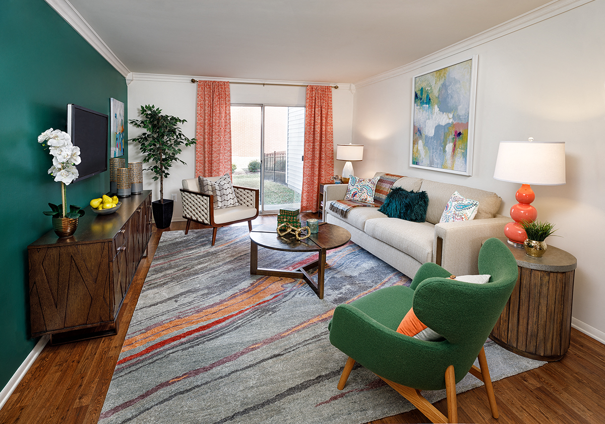 a living room with a green accent wall and a white couch