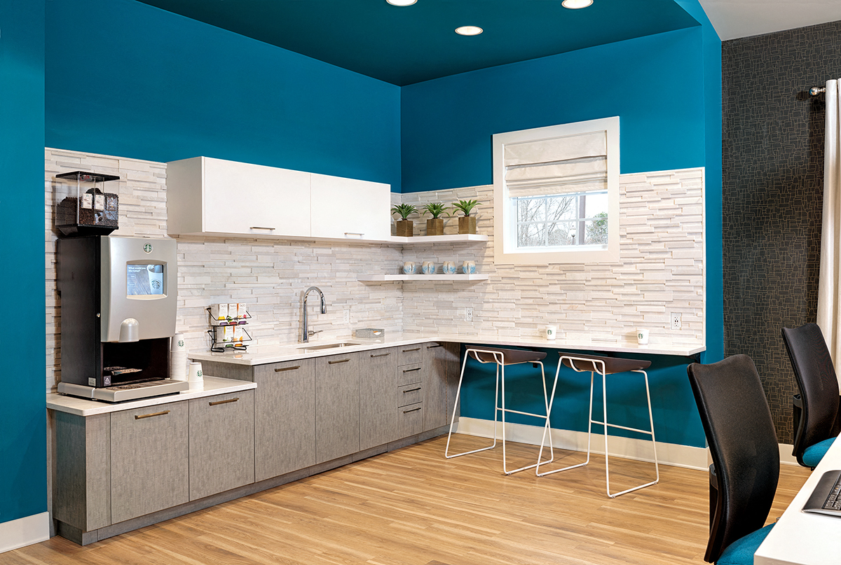 a kitchen with blue walls and white cabinets and a table and chairs