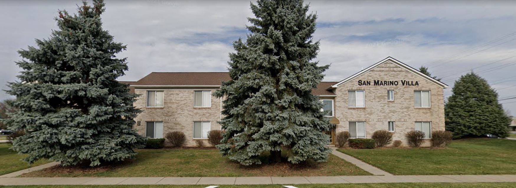 a stone building with two large trees in front of it