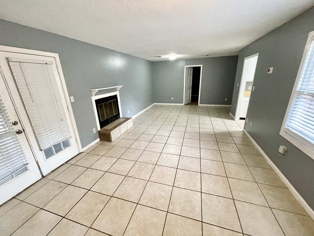 a living room with a tile floor and a fireplace