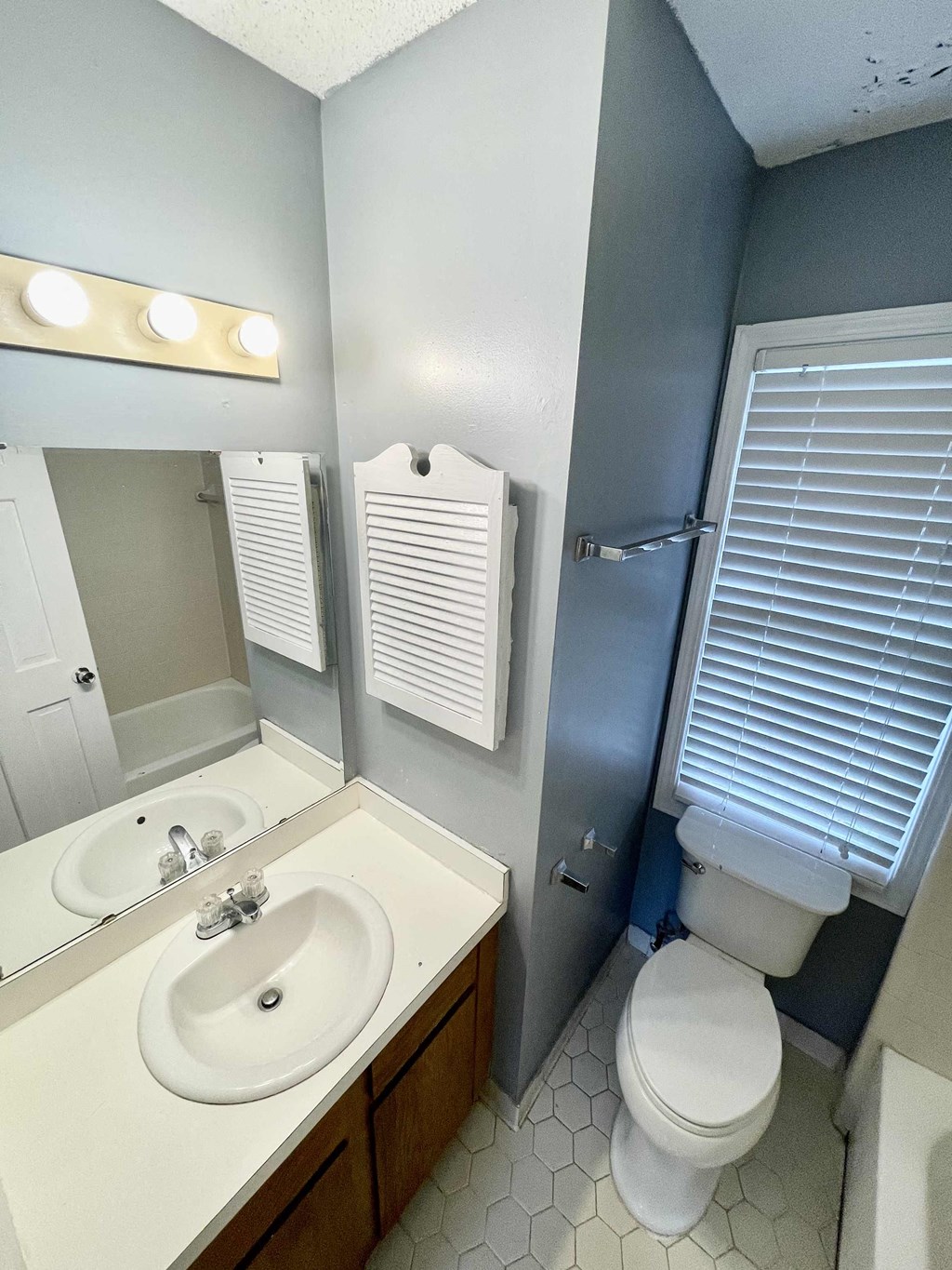 a bathroom with a sink toilet and a mirror