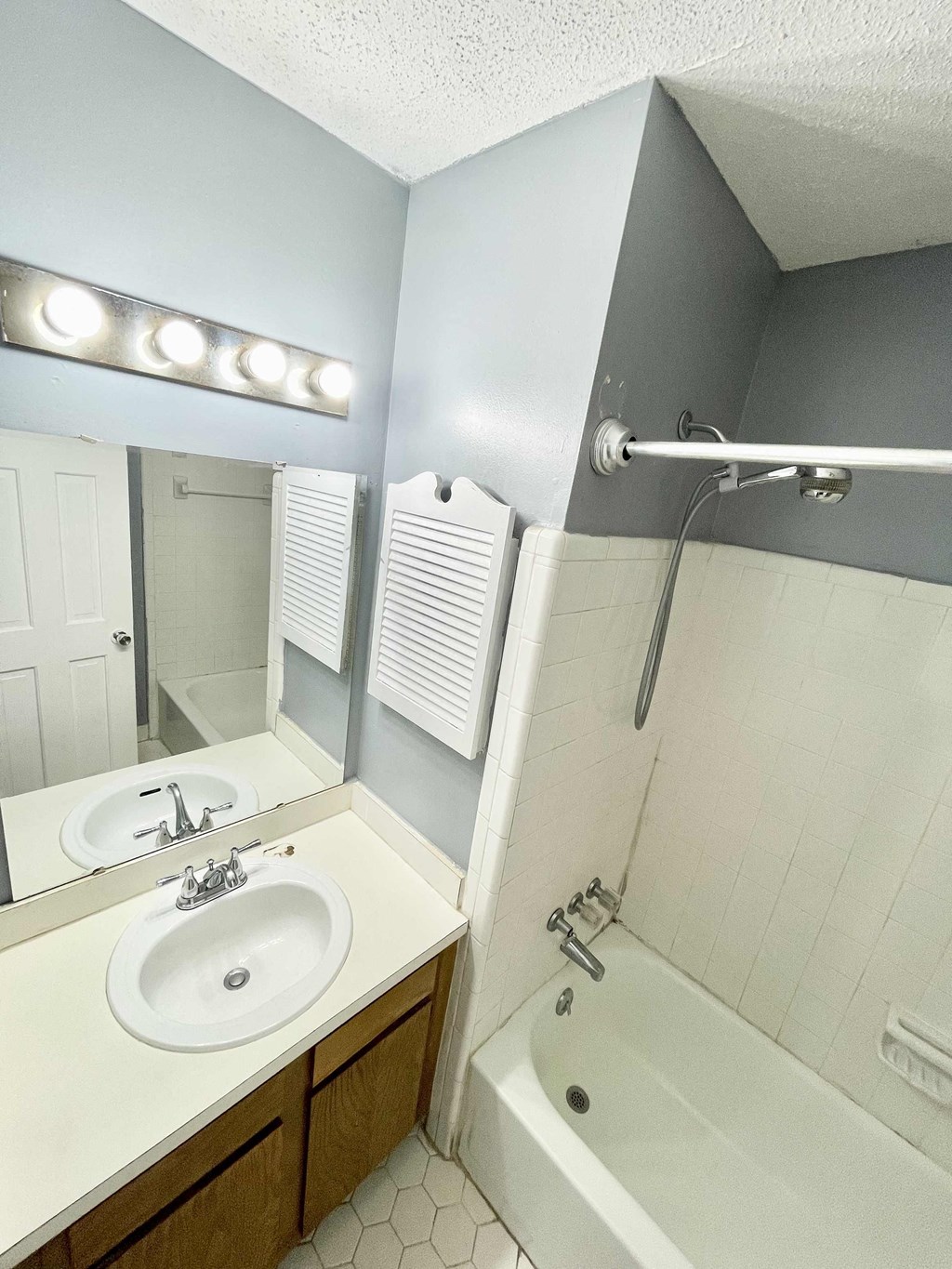 a bathroom with a sink and a tub and a mirror