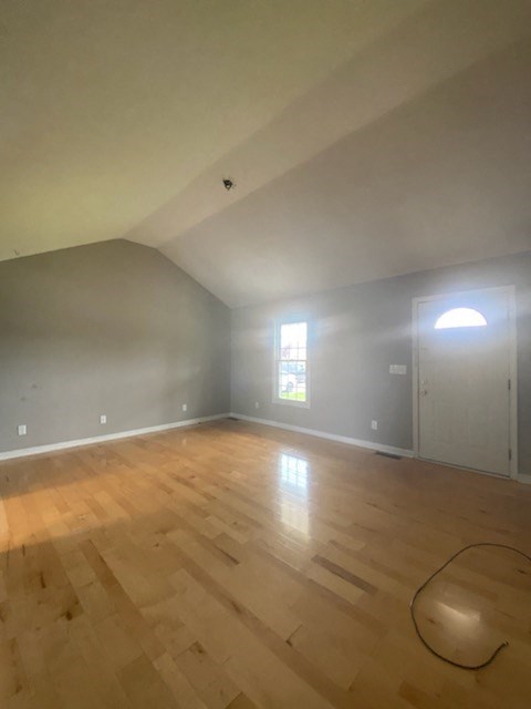 an empty living room with a hard wood floor