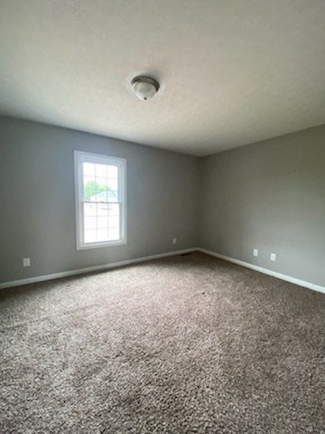 an empty room with carpet and a window