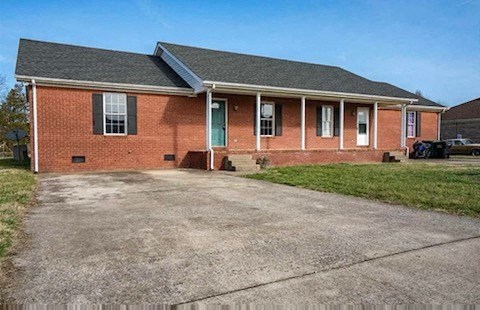 a brick house with a gravel driveway