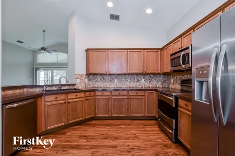 A kitchen with wooden cabinets and a stainless steel refrigerator.