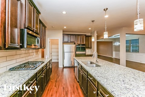 A kitchen with dark wood cabinets and granite countertops.