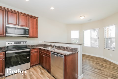 A kitchen with wooden cabinets and a stainless steel dishwasher.