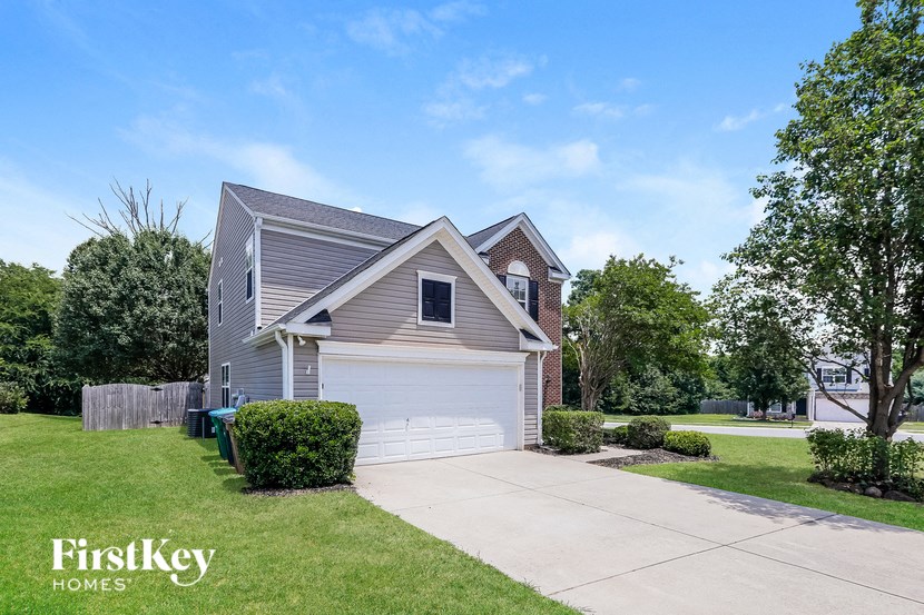 a small gray house with a white garage door