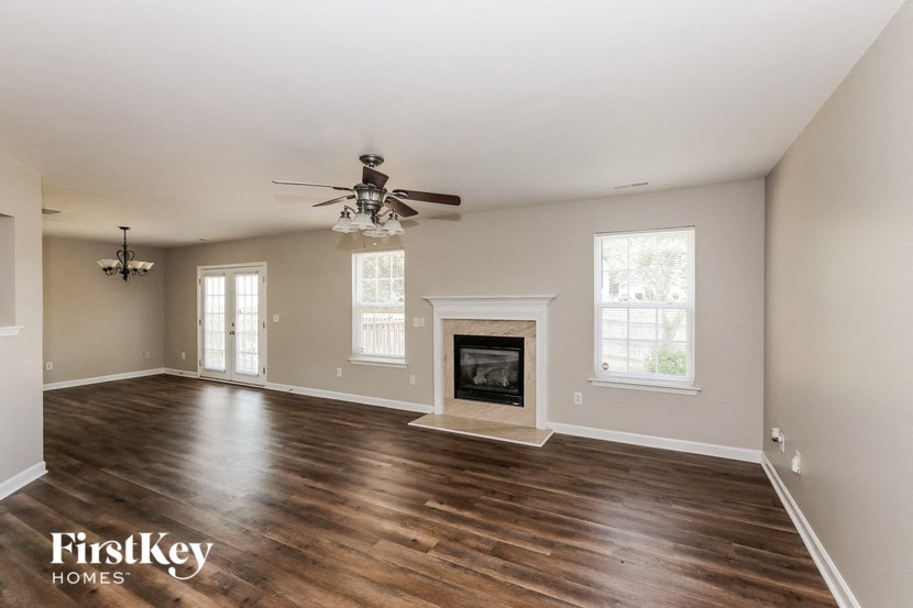 a living room with a ceiling fan and a fireplace