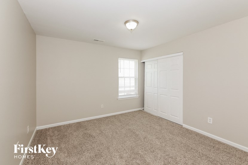 a bedroom with a white door and a carpeted floor