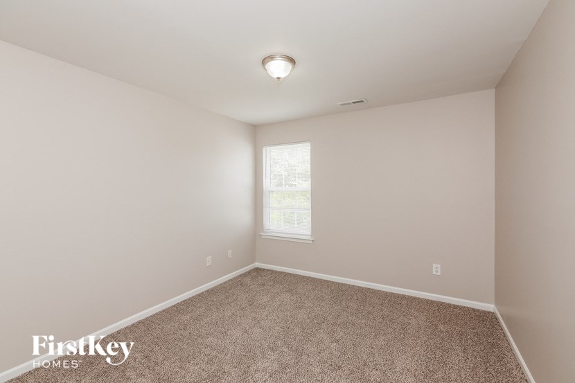 an empty room with carpet and a window