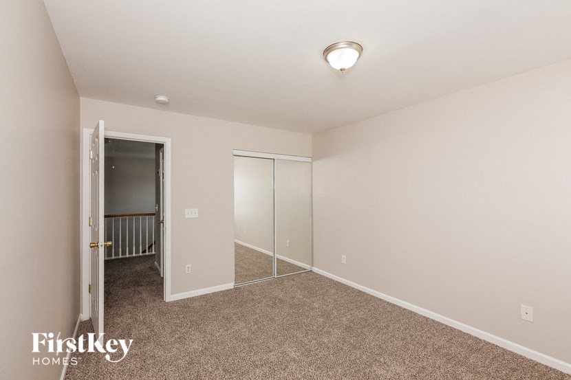 a bedroom with carpet and a door to a closet