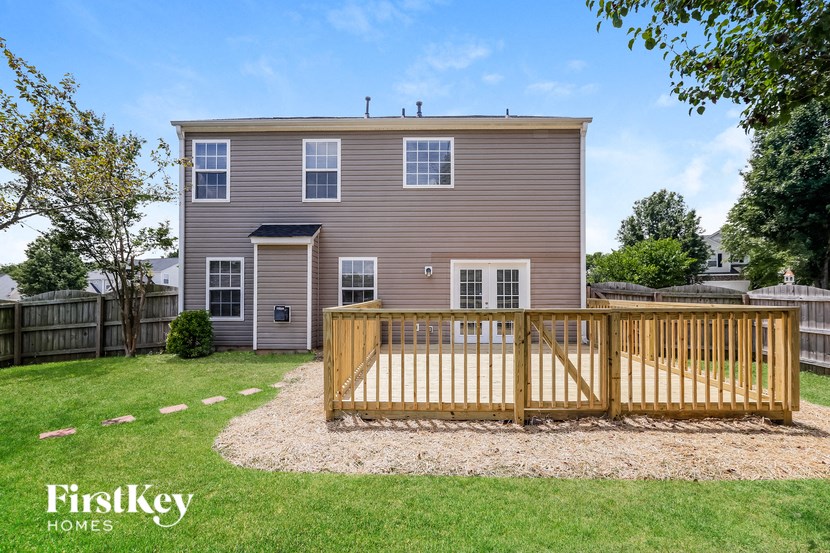a backyard deck with a house in the background