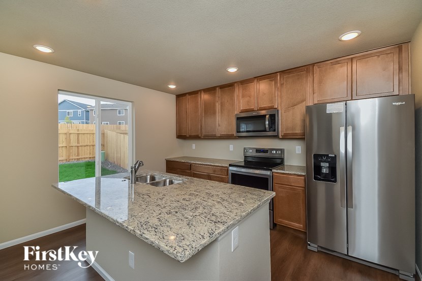A kitchen with a granite countertop and stainless steel appliances.