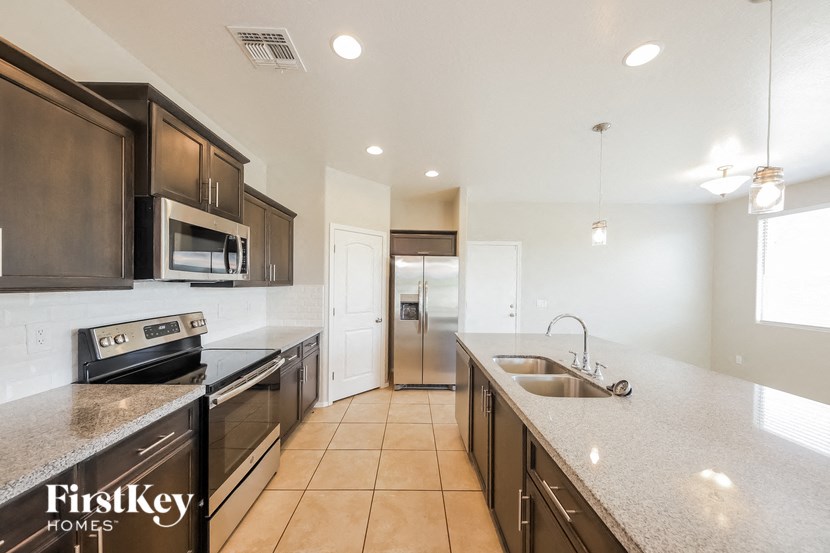 a large kitchen with granite counter tops and stainless steel appliances