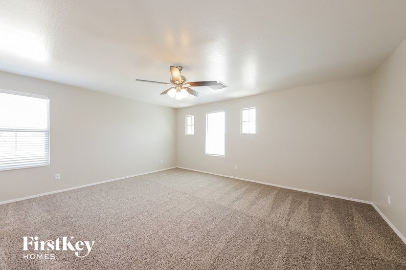 a living room with carpet and a ceiling fan