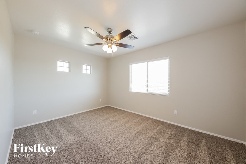 a living room with carpet and a ceiling fan
