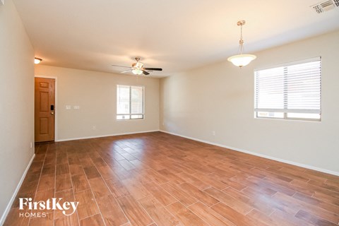 A room with wooden flooring and a ceiling fan.