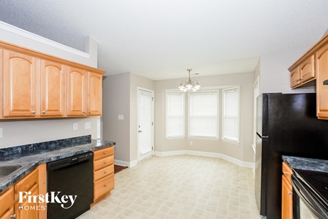 A kitchen with black appliances and wooden cabinets.