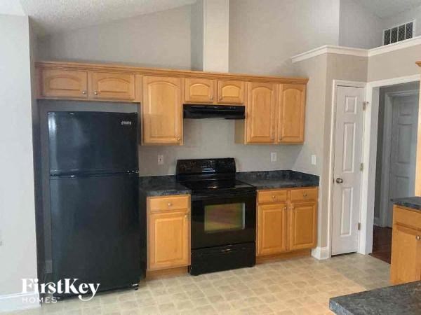 a kitchen with black appliances and wooden cabinets