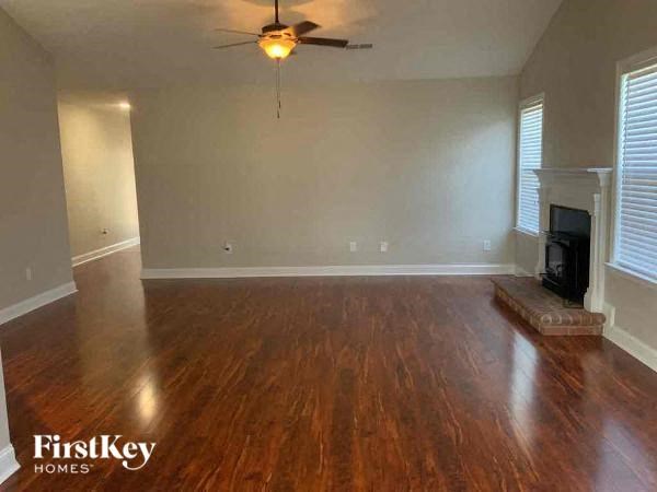 a living room with a fireplace and a ceiling fan
