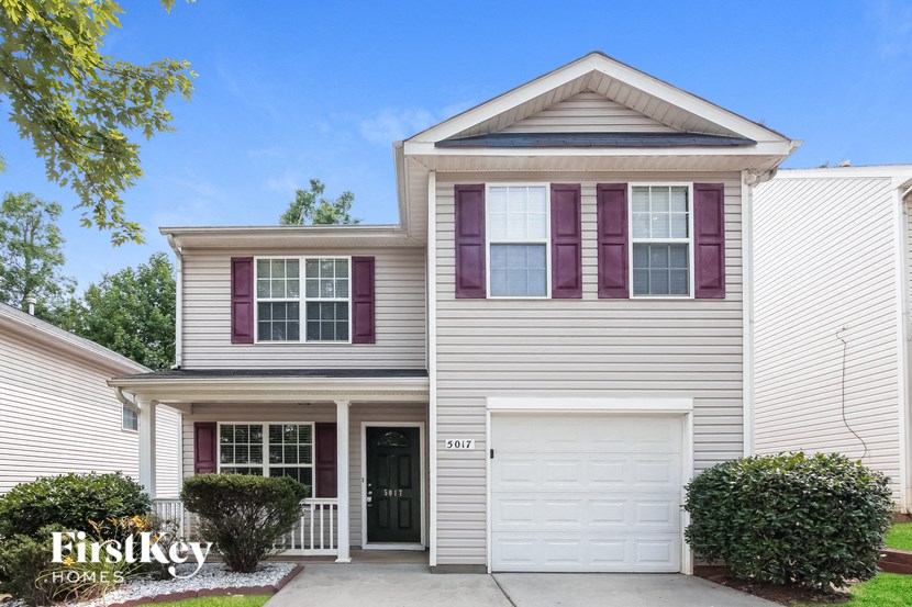 a white house with purple shutters and a white garage door